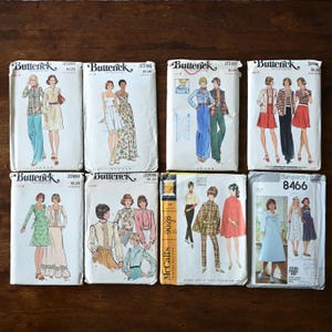 May include: A collection of vintage sewing pattern envelopes featuring illustrations of women's clothing designs. The patterns are from Butterick, McCall's, and Simplicity, with various styles from the 1970s, including dresses, tops, and pants.