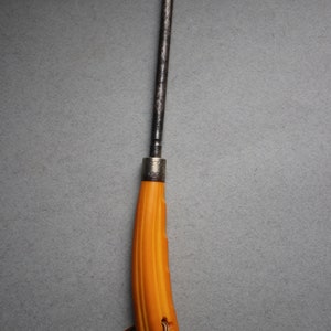 May include: A yellow handled knife with a metal blade and a brown leather cord.