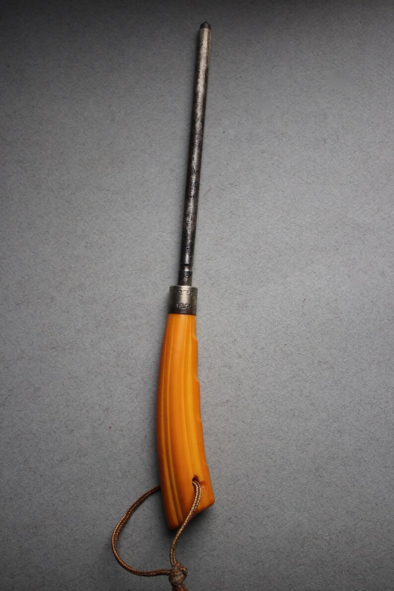 May include: A yellow handled knife with a metal blade and a brown leather cord.