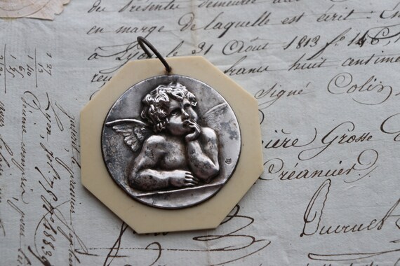 French, Infant Protection Medal of Raphael's Cherub in Silver-plate and Celluloid