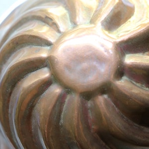 Puede incluir: Un molde de cobre vintage con un dise&ntilde;o acanalado. El molde est&aacute; hecho de cobre y tiene un acabado brillante.