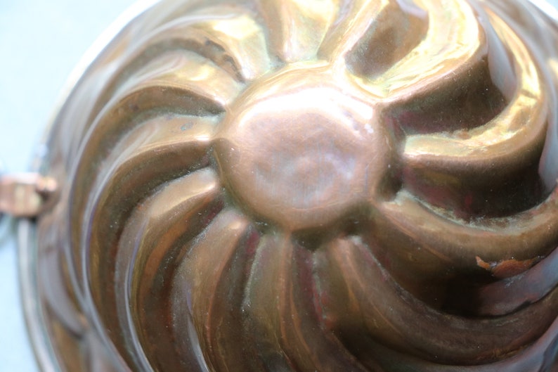 Puede incluir: Un molde de cobre vintage con un dise&ntilde;o acanalado. El molde est&aacute; hecho de cobre y tiene un acabado brillante.