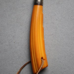 May include: A yellow and brown striped handle with a silver band and a black metal tip. The handle has a brown leather cord attached to it.