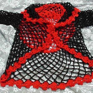 May include: Black crochet cardigan with a red crochet trim. The cardigan has a loose fit and a long, flowing design.