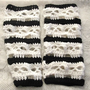 Könnte beinhalten: Ein Paar schwarze und weiße gestrickte Beinstulpen mit Totenkopf-Design. Die Beinstulpen sind mit schwarzem und weißem Garn gestreift.