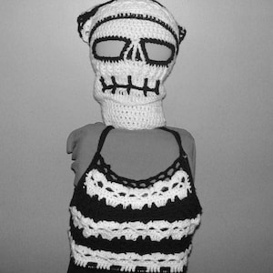 May include: Black and white crocheted skull mask with a matching striped crocheted top.