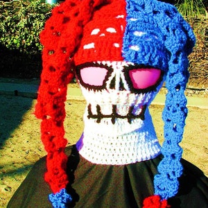 May include: A crocheted skull hat with red and blue yarn. The hat has a skull design with pink eye holes and a white crocheted neck warmer.