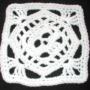 May include: White crochet square with a lacy, floral design.