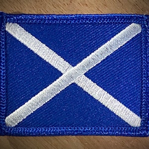 May include: A blue fabric patch with a white diagonal cross, resembling the flag of Scotland.