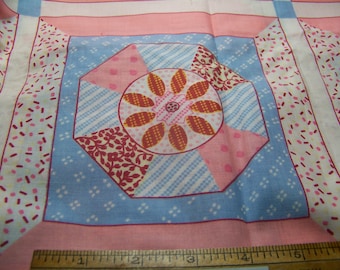 May include: A pink and blue fabric with a repeating pattern of a geometric design with a flower in the center. The fabric has a white background with small red and pink dots.