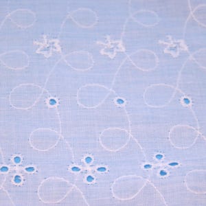 May include: A light blue fabric with a white embroidered pattern of delicate flowers and vines.
