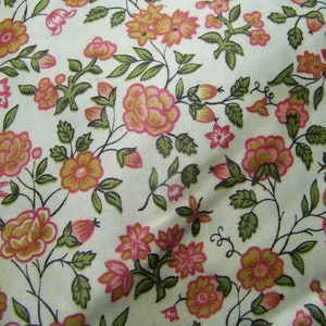 May include: A white fabric with a repeating pattern of pink and orange flowers with green leaves. The flowers are stylized and have a vintage look.