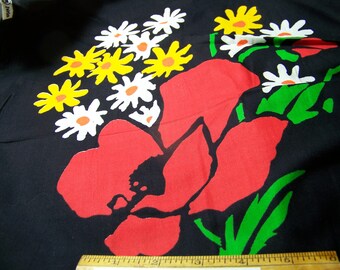 May include: Black fabric with a red poppy and white daisies with yellow centers. The flowers are stylized and have green leaves.