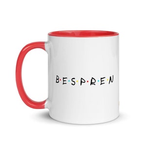 Peut inclure: Mug en céramique blanche avec intérieur et anse rouges. Le mug présente le mot "BESPREN" en lettres noires, chaque lettre étant séparée par un point coloré, rappelant le logo d'une émission de télévision populaire. Un design simple mais accrocheur.