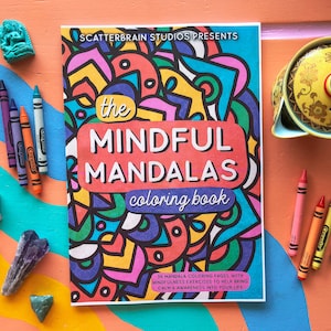 May include: A colorful coloring book titled "The Mindful Mandalas Coloring Book" with 36 mandala coloring pages and mindfulness exercises to help bring calm and awareness into your life. The cover features a vibrant mandala design with a variety of colors and patterns.