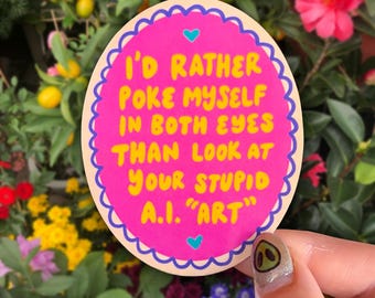 Könnte beinhalten: Ein ovaler Aufkleber mit leuchtend rosa Hintergrund und einem gewellten violetten Rand. Der gelbe Text lautet: I'D RATHER POKE MYSELF IN BOTH EYES THAN LOOK AT YOUR STUPID A.I. "ART". Zwei kleine hellblaue Herzen befinden sich über und unter dem Text.
