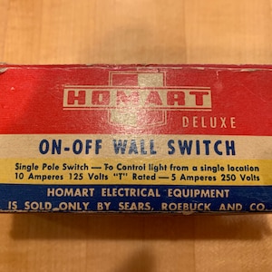 May include: A red and blue box with the text "HOMART DELUXE ON-OFF WALL SWITCH" and the text "Single Pole Switch - To Control light from a single location 10 Amperes 125 Volts "T" Rated - 5 Amperes 250 Volts HOMART ELECTRICAL EQUIPMENT IS SOLD ONLY BY SEARS, ROEBUCK AND CO."