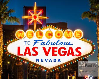 May include: Iconic "Welcome to Fabulous Las Vegas Nevada" sign at dusk. The sign is white with red, blue, and yellow text, surrounded by colorful lights and palm trees. A large star is at the top.