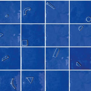 Puede incluir: Una cuadrícula de veinticuatro baldosas azul cobalto brillante. Cada baldosa presenta una forma geométrica en relieve, delineada en blanco, que incluye círculos, cuadrados, rectángulos y líneas curvas. Las formas están espaciadas uniformemente.