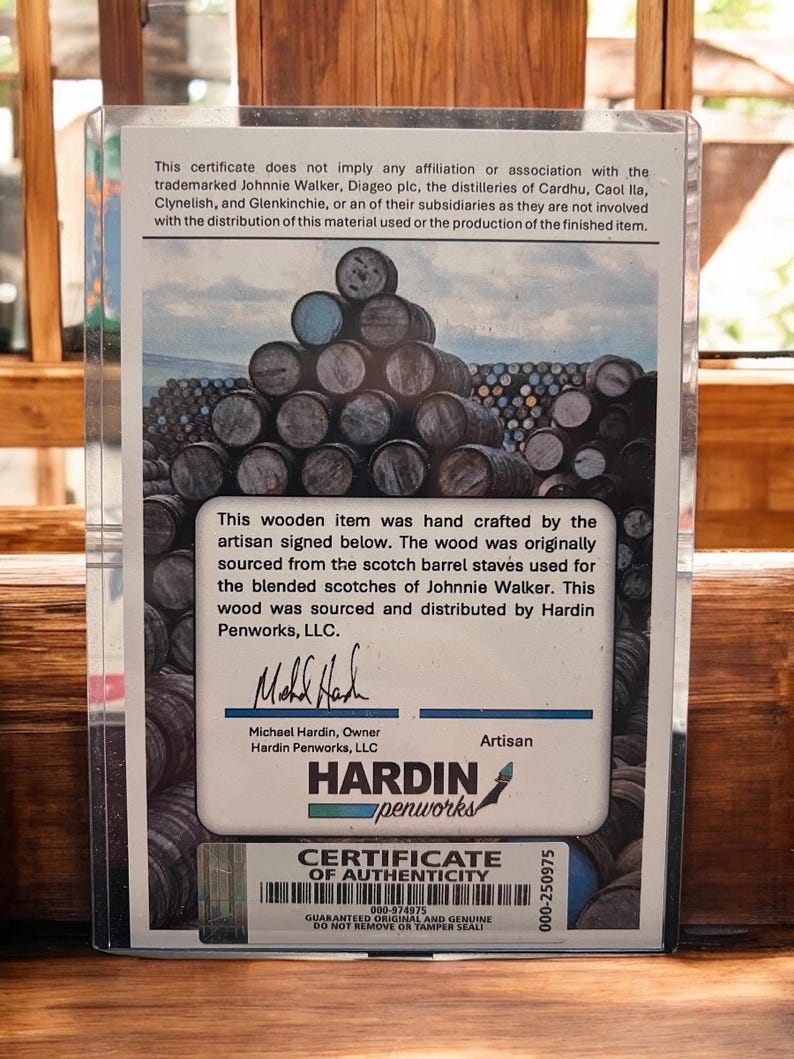 Pu&ograve; includere: Certificato di autenticit&agrave; in una custodia di plastica trasparente. Il certificato presenta un'immagine di botti di legno impilate e testo sull'origine dell'articolo da doghe di botti di whisky Johnnie Walker. Il logo Hardin Penworks &egrave; visibile.