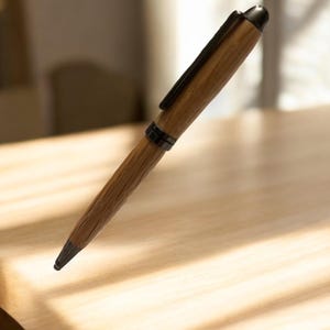 Pu&ograve; includere: Una penna in legno con clip e punta in metallo scuro. La penna presenta un motivo a venature naturali e un cappuccio nero. La penna &egrave; appoggiata su una superficie di legno chiaro.