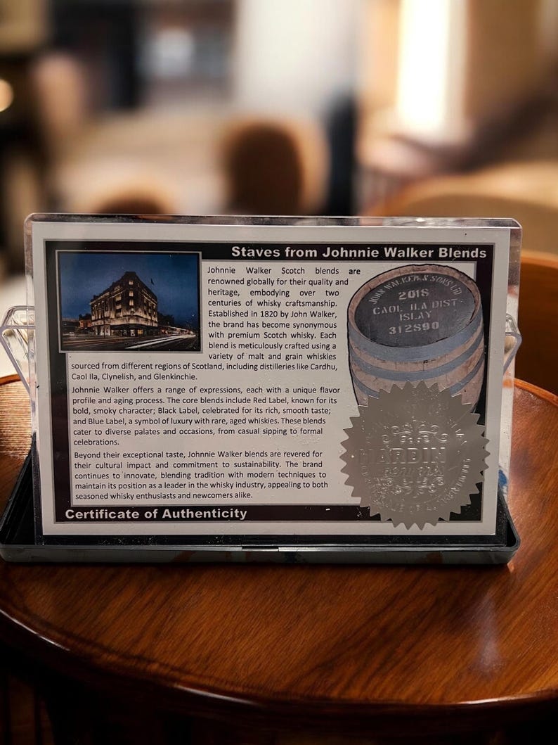 Pu&ograve; includere: Primo piano di un certificato di autenticit&agrave; delle miscele di Scotch Johnnie Walker. Il certificato include testo sulla storia del marchio e un'immagine di un edificio. &Egrave; presente anche una piccola immagine di botte.