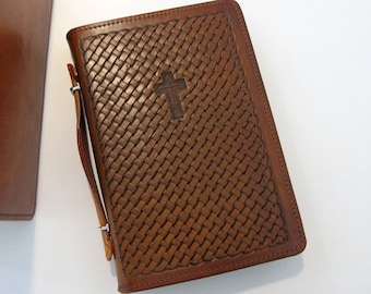 May include: Two brown leather bible covers. One cover has a woven pattern and a cross embossed on the front. The other cover has two leather handles and silver clasps.