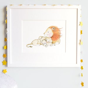 May include: A watercolor illustration of a lion with a mane and two cubs. The lion is lying down with its cubs nestled against it. The illustration is framed in a white frame.
