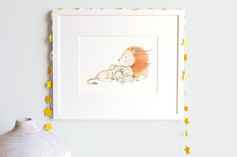 May include: A watercolor illustration of a lion with a mane and two cubs. The lion is lying down with its cubs nestled against it. The illustration is framed in a white frame.
