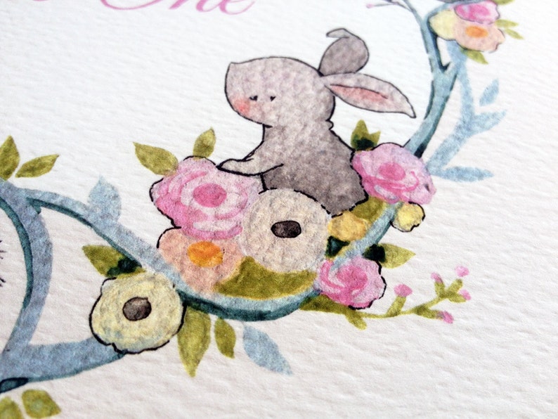 May include: A watercolor illustration of a gray bunny sitting on a branch with pink, yellow, and white flowers. The bunny is surrounded by green leaves and the branch is painted in a light blue color.