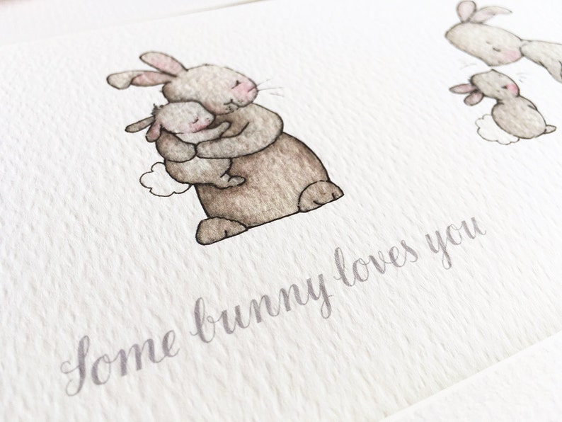 May include: A watercolor illustration of a brown bunny holding a smaller brown bunny. The text "some bunny loves you" is written below the bunnies.