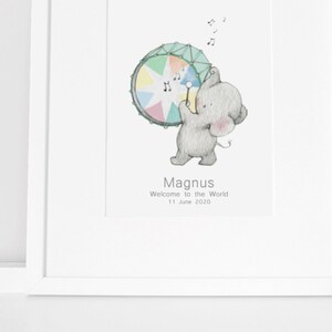 May include: A watercolor illustration of a gray elephant playing a rainbow drum with musical notes above. The text below reads "Magnus Welcome to the World 11 June 2020".