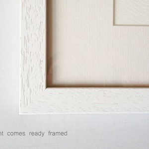 May include: A white wood picture frame with a white mat. The frame has a slightly textured surface. This print comes ready framed.