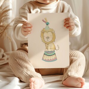 May include: A watercolour illustration of a lion wearing a party hat, sitting on a colourful circus-style platform. The lion has a yellow mane and is depicted in a whimsical, cartoon style. The artwork is on cream-coloured paper.