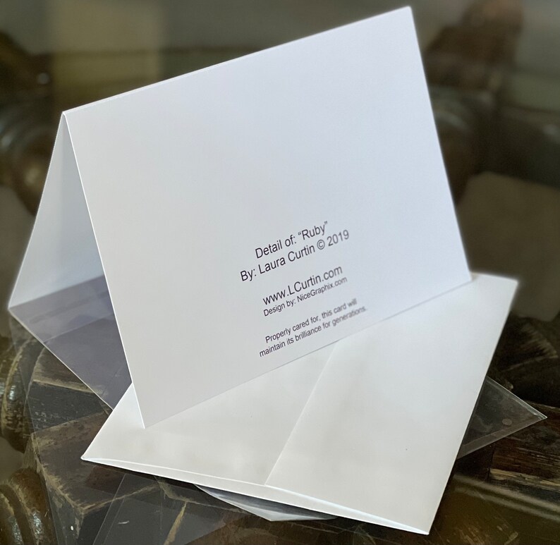 Peut inclure: Une carte blanche avec le texte "Detail of: "Ruby" By: Laura Curtin &copy; 2019 www.LCurtin.com Design by: NiceGraphix.com Property cared for, this card will maintain its brilliance for generations."