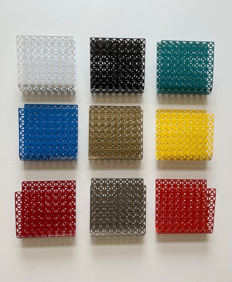 May include: Nine square metal wall organizers in various colors, including white, black, teal, blue, brown, yellow, gray, and red. Each organizer features a geometric pattern.