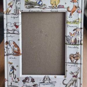 May include: A white rectangular picture frame featuring colorful watercolor illustrations of various dog breeds in different poses. The frame includes the text My Dog is... followed by descriptive words like Exhausted, Round, Bouncy, Sociable, Energetic, Imaginative, Fluffy, Wet, Dexterous, Kind, Jaunty, and Loyal.