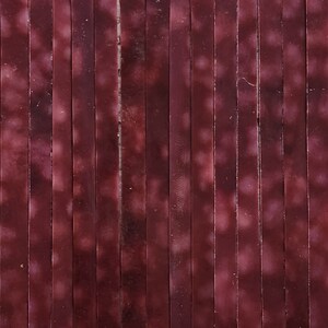 May include: A close-up of a wall made of many thin, vertical, wooden slats. The slats are painted a deep burgundy color with a subtle, faded, white pattern.