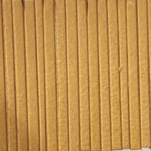 May include: A close-up of a wall made of many thin, vertical, wooden slats. The slats are a light brown color and have a slightly textured surface.