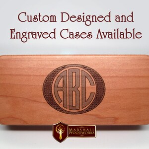 May include: A close-up of a wooden box with a custom engraved monogram of the letters "ABC" in a circle. The box is made of light wood and has a smooth finish. The engraving is dark brown and is centered on the box. The text "Custom Designed and Engraved Cases Available" is visible at the top of the image.