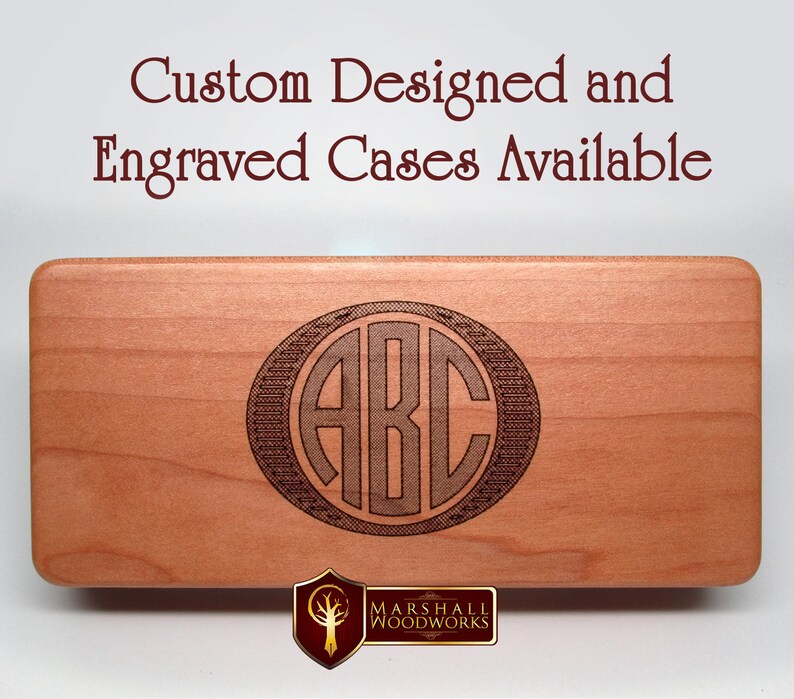 May include: A close-up of a wooden box with a custom engraved monogram of the letters "ABC" in a circle. The box is made of light wood and has a smooth finish. The engraving is dark brown and is centered on the box. The text "Custom Designed and Engraved Cases Available" is visible at the top of the image.