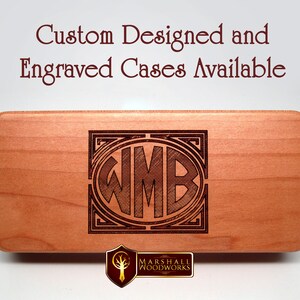 May include: A wooden box with a custom engraved monogram "WMB" in a decorative frame. The box is made by Marshall Woodworks and is available for custom design and engraving.