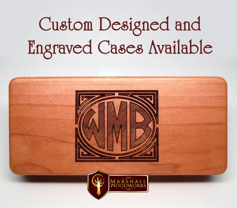 May include: A wooden box with a custom engraved monogram "WMB" in a decorative frame. The box is made by Marshall Woodworks and is available for custom design and engraving.