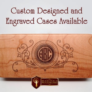 May include: A wooden box with a custom engraved design featuring a monogram of the letters "ABC" in a circle surrounded by decorative flourishes. The box is made by Marshall Woodworks.