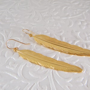 Gold feather dangle earrings