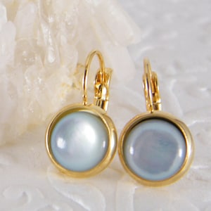 May include: A pair of gold hoop earrings with a white pearl-like center. The earrings have a simple design and are perfect for everyday wear.
