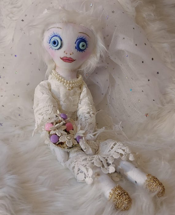 A one-of-a-kind handmade fabric art doll with an eerie bridal aesthetic that sits perfectly in the 'oddity cabinet' niche — no two are alike.