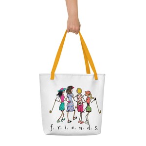 May include: White tote bag with yellow handles featuring a cartoon illustration of four women playing golf. The text "f.r.i.e.n.d.s." is printed at the bottom of the bag.