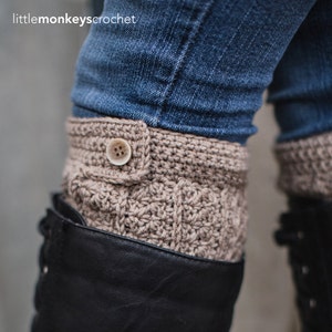 Op de afbeelding: Gebreide laarscuffs in een neutrale bruine kleur met een knoopsluiting. De cuffs worden gedragen over zwarte laarzen en onder een blauwe jeans. De tekst "littlemonkeyscrochet" is zichtbaar bovenaan de afbeelding.