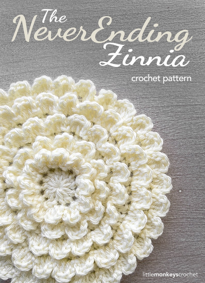 May include: A close-up of a crocheted white flower, called "The Never Ending Zinnia", with a crochet pattern.
